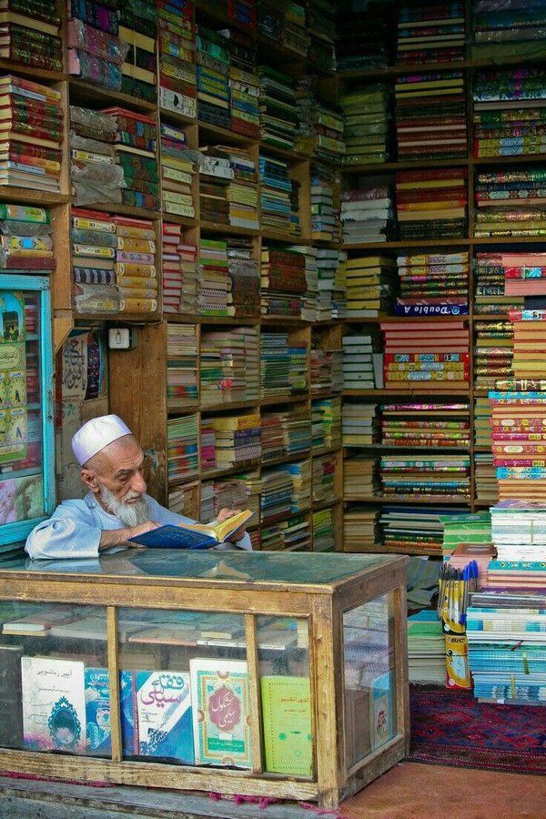 A bookseller reading in his shop